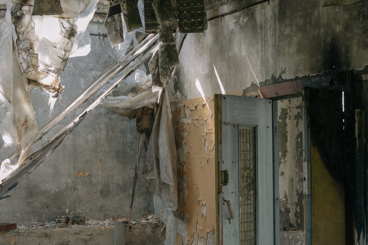 Explore the eerie silence of a decaying, abandoned interior with peeling walls and broken structures.